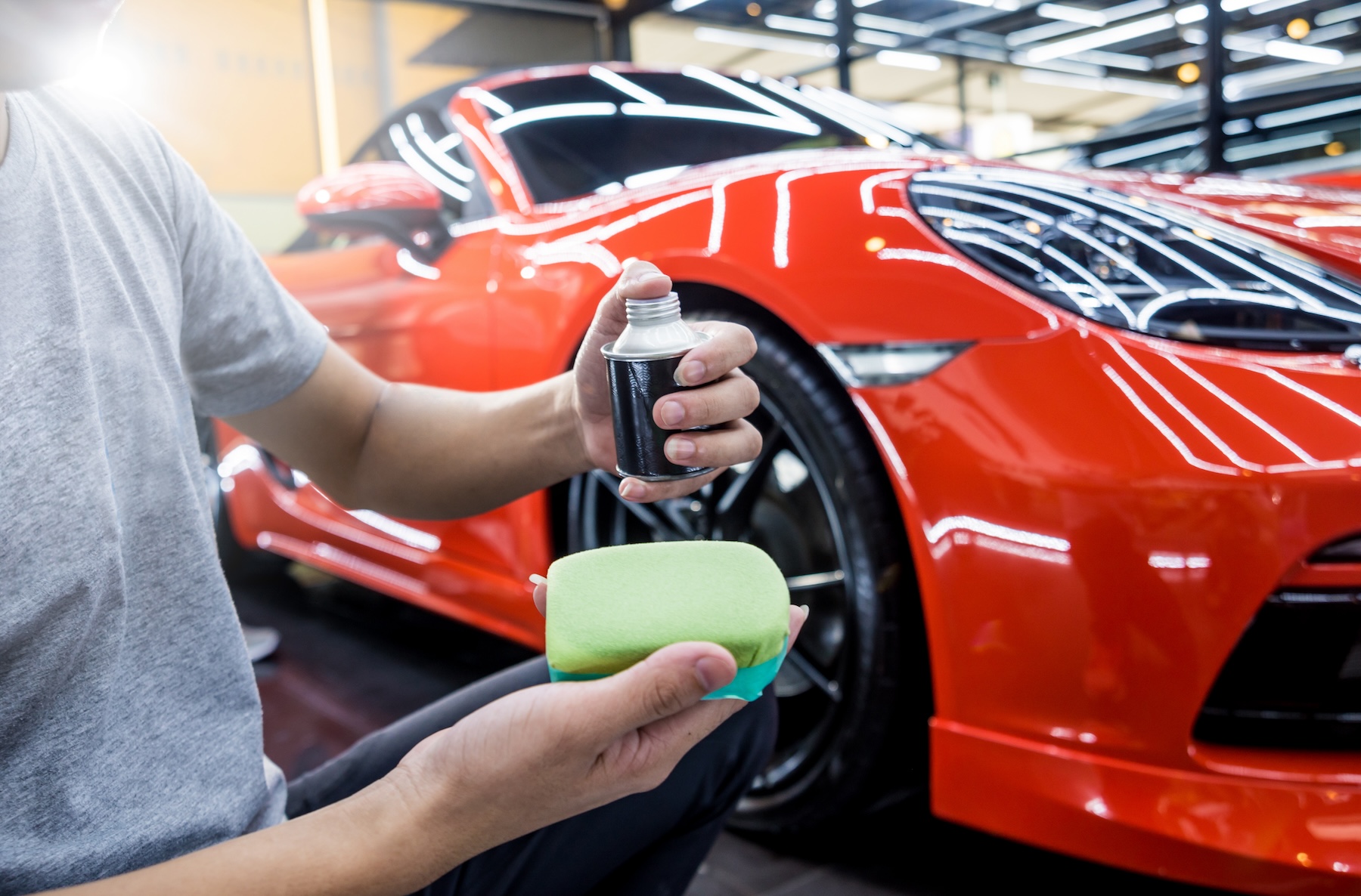 Car service worker applying nano coating on a car detail